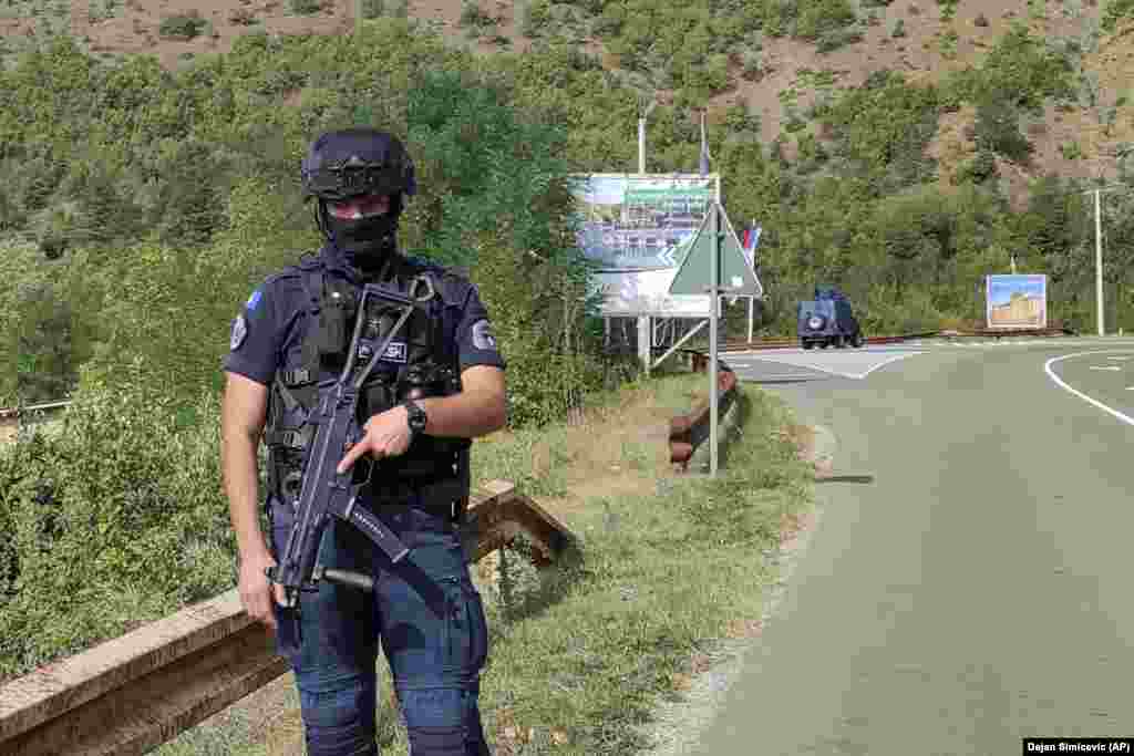 Një pjesëtar i Policisë së Kosovës duke qëndruar në një rrugë afër Banjskës.