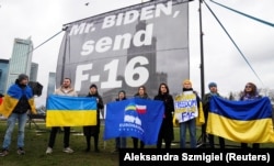 Участники акции в поддержку Украины призывают президента США Джо Байдена предоставить Украине самолеты F-16 у гостиницы Marriott, где Байден остановился во время своего визита в Польшу. Варшаве, 22 февраля 2023 года