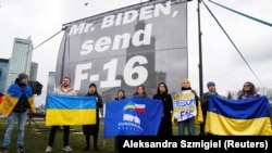 Acțiune de protest la Varșovia, în timpul vizitei președintelui Biden în Polonia, din februarie anul acesta. Participanții la protest, aflați în fața Hotelului Marriott, unde stătea Biden, îi cereau atunci președintelui american să trimită avioane F-16 în Ucraina.