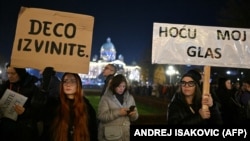 Сторонники оппозиции держат плакаты с надписями "Извините, дети" и "Я хочу свой голос", 18 декабря 2023 года, Белград
