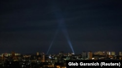 Українські військові використовують прожектори, коли шукають безпілотники в небі над містом під час російської атаки на Київ, 4 травня 2023 року