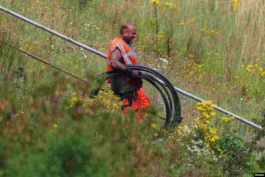 Radnik željezničke kompanije SNCF nosi nove kablove&nbsp;do mjesta&nbsp;vandalskog napada na francusku liniju brzih vozova u Croisillesu na sjevernu Francuske, 26. jula 2024. Ozbilji poremećaji koji su pogodili 26. jula mrežu SNCF-a je posljedica &quot;sabotaže&quot; koja je izgleda koordinisana, rekao je za AFP izvor blizak tom slučaju.