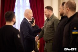 Президента США Джо Байдена (в центре) приветствует Андрей Ермак, глава Офиса президента Украины, во время встречи в Киеве 20 февраля 2023 года