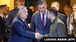 Volodimir Zelenszkij ukrán elnök kezet fog Orbán Viktor magyar miniszterelnökkel az Európai Politikai Közösség csúcstalálkozójának plenáris ülése előtt Granadában 2023. október 5-én. 