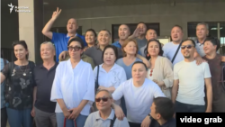 Protesters pose with their lawyers after being acquitted by a Bishkek court on June 14.