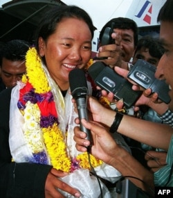  Лакпа Шерпа приказва пред медиите при завръщането си от първата си сполучлива експедиция до Еверест, 27 май 2000 година 