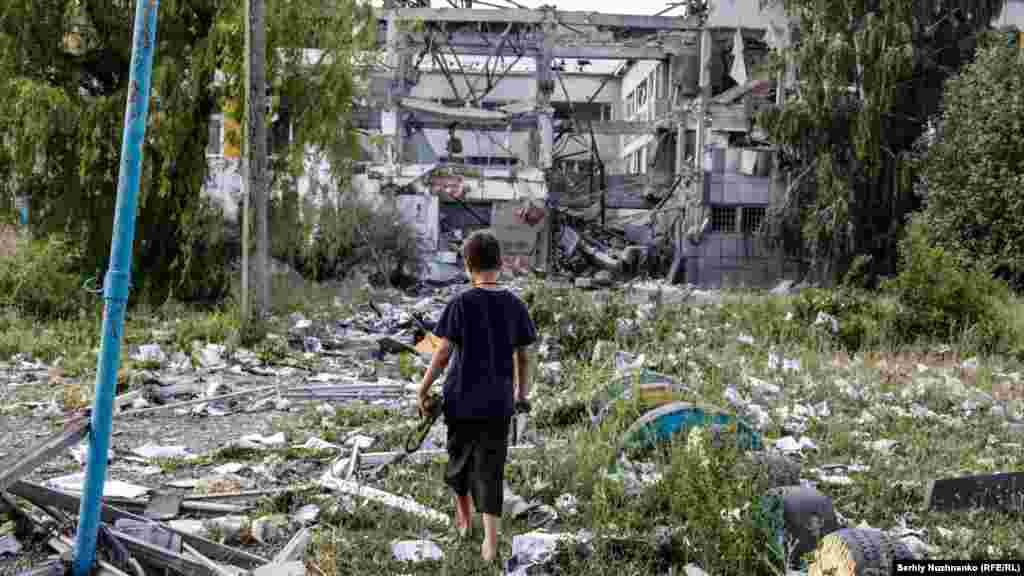 A student walks through the debris of his school, which was destroyed by a Russian air strike, in Bakhmut, in the Donetsk region, on June 8, 2022.