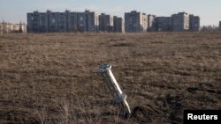 Изпразнен контейнер с касетъчни боеприпаси стои забит в земята пред жилищни блокове в град Енакиеве, Донецка област през 2015 г. Снимката е илюстративна.