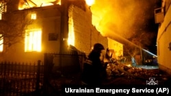 In this photo provided by the Ukrainian Emergency Service, firefighters work at the site of a burning building after a Russian drone attack in Dublyany on January 1.