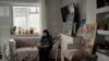 Ольга Александровна в гостиной в окружении своих картин. На подоконнике кот Басё, на коленях беременная Муся, у дивана - кот Васенька.