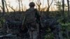A Ukrainian soldier walks to his position at the front line a few kilometers from Andriyivka.
