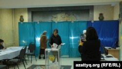 Член избиркома на участке № 161 в Алматы фотографирует избирательницу, предположительно, по просьбе последней. Алматы, 19 марта 2023 года