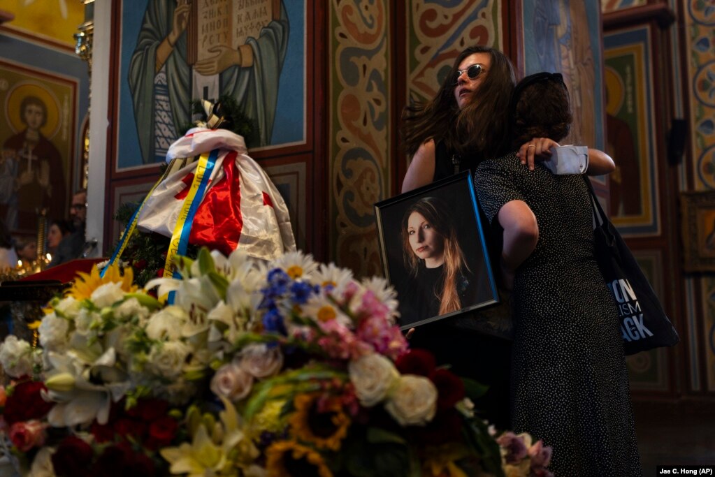 Duke mbajtur një fotografi të shkrimtares ukrainase, Viktoria Amelina, Sofiya Chelyak shihet duke përqafuar një grua gjatë një shërbimi përkujtimor për Amelinën, në Kiev. Shkrimtarja, fituese e disa çmimeve, u vra javën e kaluar, nga një sulm rus me raketë ndaj një restoranti të frekuentuar nga gazetarët dhe aktivistët humanitarë, në Ukrainën lindore.