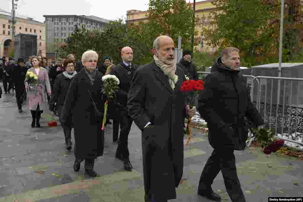In Moscow, members of diplomatic missions carry flowers to a monument near the Federal Security Service building on the eve of Russia&#39;s Remembrance Day for the Victims of Political Repression.&nbsp;The ceremony was held at the Solovetsky Stone monument, a large boulder from the Solovetsky Islands, where the first camp of the gulag political-prison system was located. The October 29 event came amid a Kremlin crackdown on dissent more than 20 months after Russia&#39;s full-scale invasion of Ukraine. &nbsp;