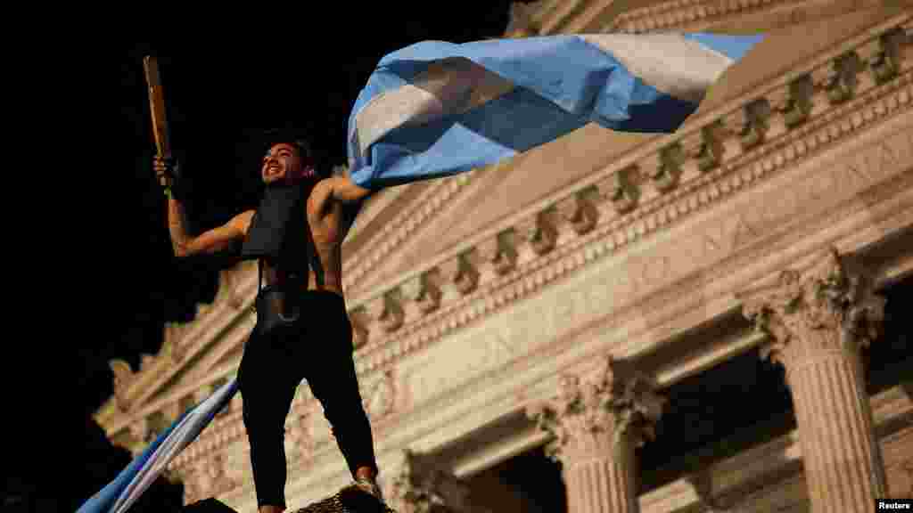 Egy tüntető argentin zászlót tart az argentin elnök, Javier Milei kiigazítási politikája elleni tüntetésen a Nemzeti Kongresszus előtt Buenos Airesben 2023. december 21-én