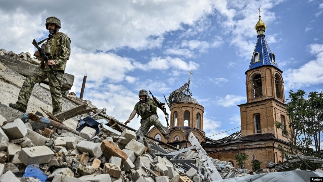 Soldați ucraineni patrulează o zonă avariată de loviturile militare rusești în orașul Orikiv din regiunea Zaporojie. 20 mai 2024.