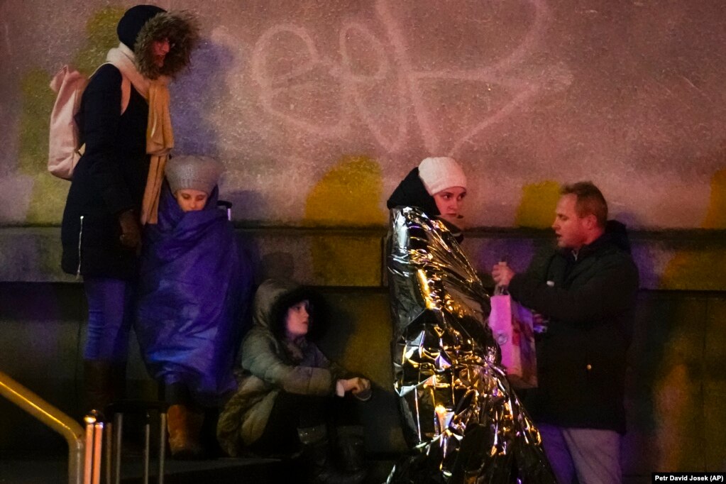 People wait near the building of the Philosophical Faculty of Charles University in downtown Prague on December 21.