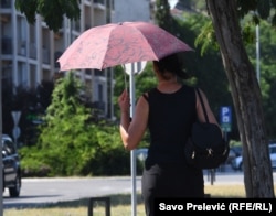 Žena sa kišobranom u Podgorici tokom toplotnog talasa