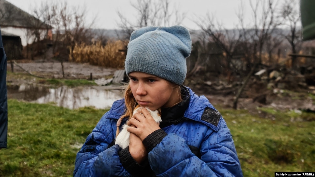 Një vajzë 9-vjeçare e quajtur Sofiyka përqafon kafshën e saj, një brejtës, gjatë evakuimit nga Makijivka, në rajonin lindor të Luhanskut, më 19 nëntor 2022. &nbsp;