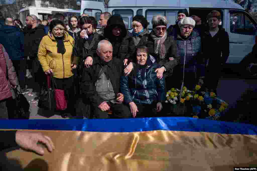 Relatives mourn next to the coffin of a Ukrainian serviceman who recently died in battle, during his funeral ceremony in Poltava in central Ukraine.&nbsp;
