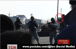Скриншот видео: боец "Беркута" стреляет под ноги митингующих на Чонгаре, 10 марта 2014 года