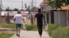 Two boys take bottles to fill with drinking water in Bishkek, where modest rations of water are distributed from a tanker once a day.