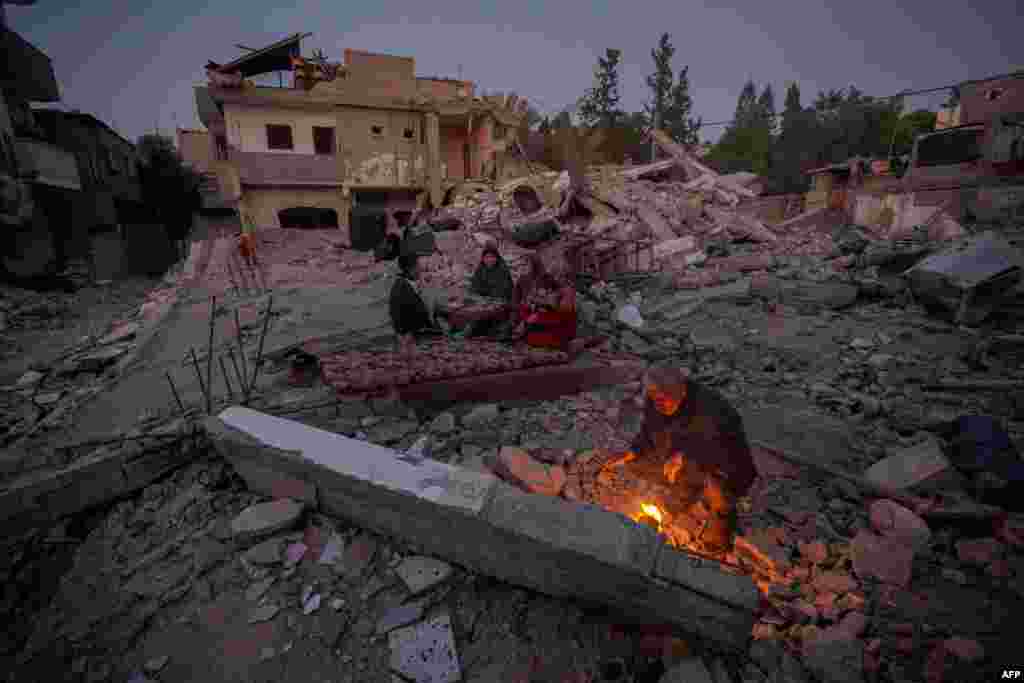 Palestinska porodica Al-Naji priprema se iftar, prekid posta, prvog dana muslimanskog svetog mjeseca posta ramazana na ruševinama svoje porodične kuće u Deir el-Balahu, centralni dio Pojasa Gaze, 11. marta. Najsmrtonosniji rat u Gazi ne pokazuje znakove jenjavanja s početkom ramazana usred iscrpljujuće humanitarne krize koja je veliki dio palestinske teritorije gurnula na rub gladi, prenosi AFP.