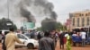 Qytetarët shikojnë tymin duke dalë nga ndërtesa e partisë së presidentit të rrëzuar nga pushteti në Niger.