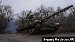 Украински военнослужещи карат танк към предните позиции на боевете близо до Бахмут, Украйна, март 2023 г.