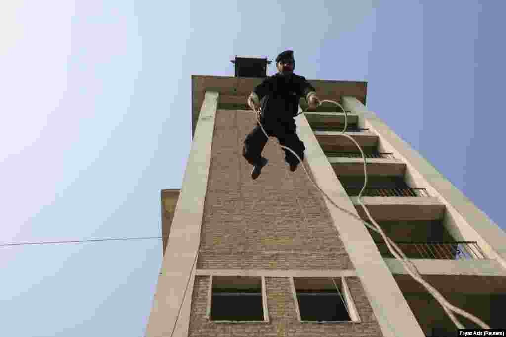 A police officer rappels off a building during a practice session at the training center. The police in Khyber-Pakhtunkhwa Province, which neighbors Islamabad, say they are up for the fight but lack the resources that they need to be effective.