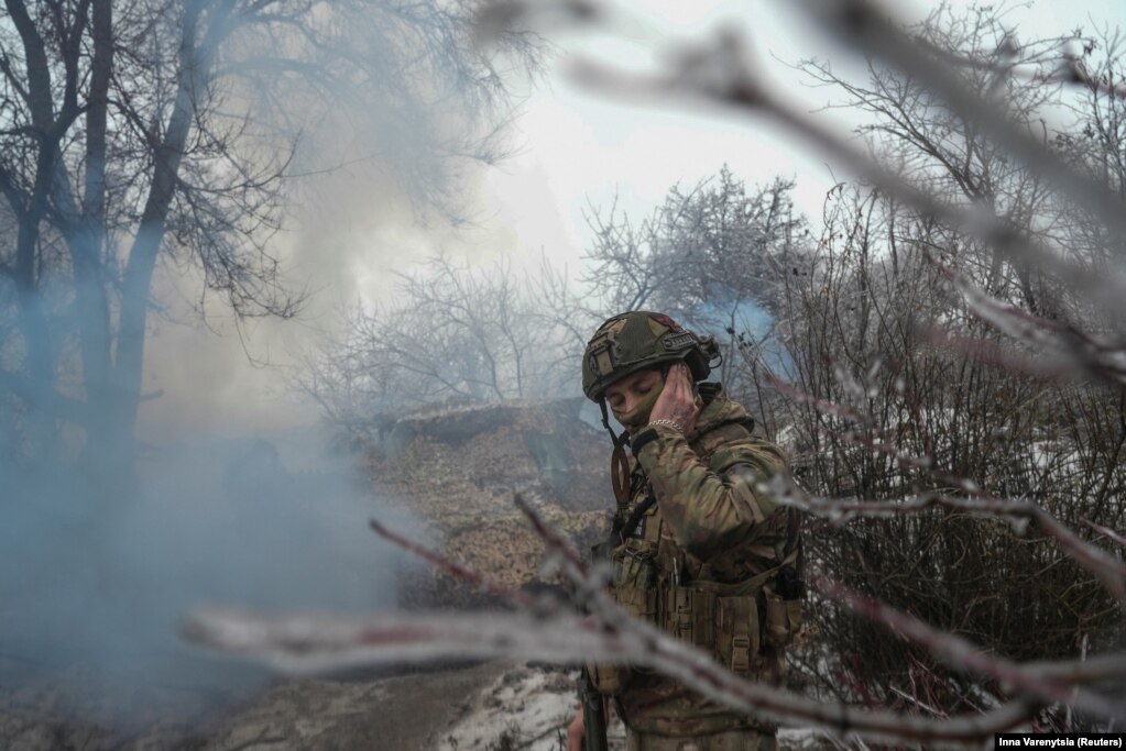 Një ushtar mbyll veshët ndërsa obusi Gvozdivka qëllon mbi pozicionet ruse pranë Bahmutit. Pas 22 muajsh lufte përgjatë vijës së frontit prej 1000 kilometrash, as Ukraina dhe as Rusia nuk po fitojnë terren të rëndësishëm.