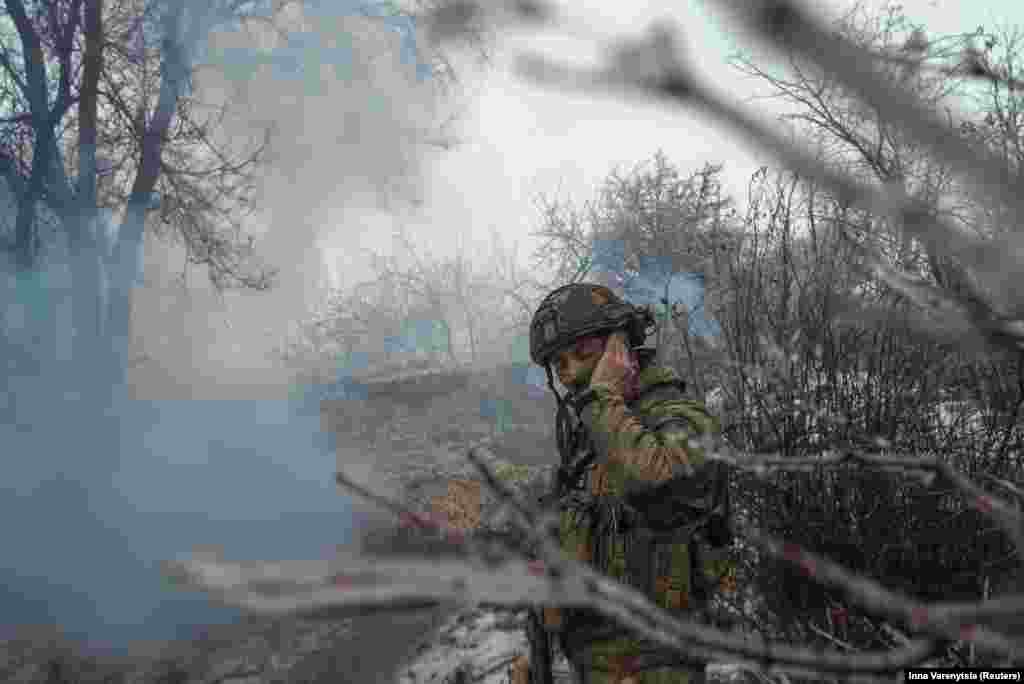 A soldier covers his ears as the Gvozdivka fires onto Russian positions near Bakhmut. After 22 months of war along the 1,000-kilometer front line, neither Ukraine nor Russia are gaining significant ground.