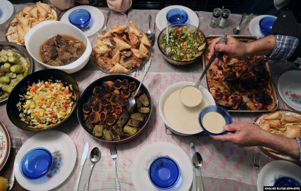 Një familje egjiptiane duke shërbyer ushqimin e përgatitur për iftar në ditën e parë të Ramazanit në Kajro, Egjipt.