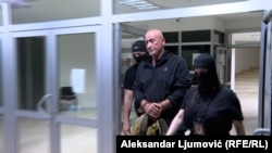 Police escort former chief special prosecutor Milivoje Katnic in detention on April 14.