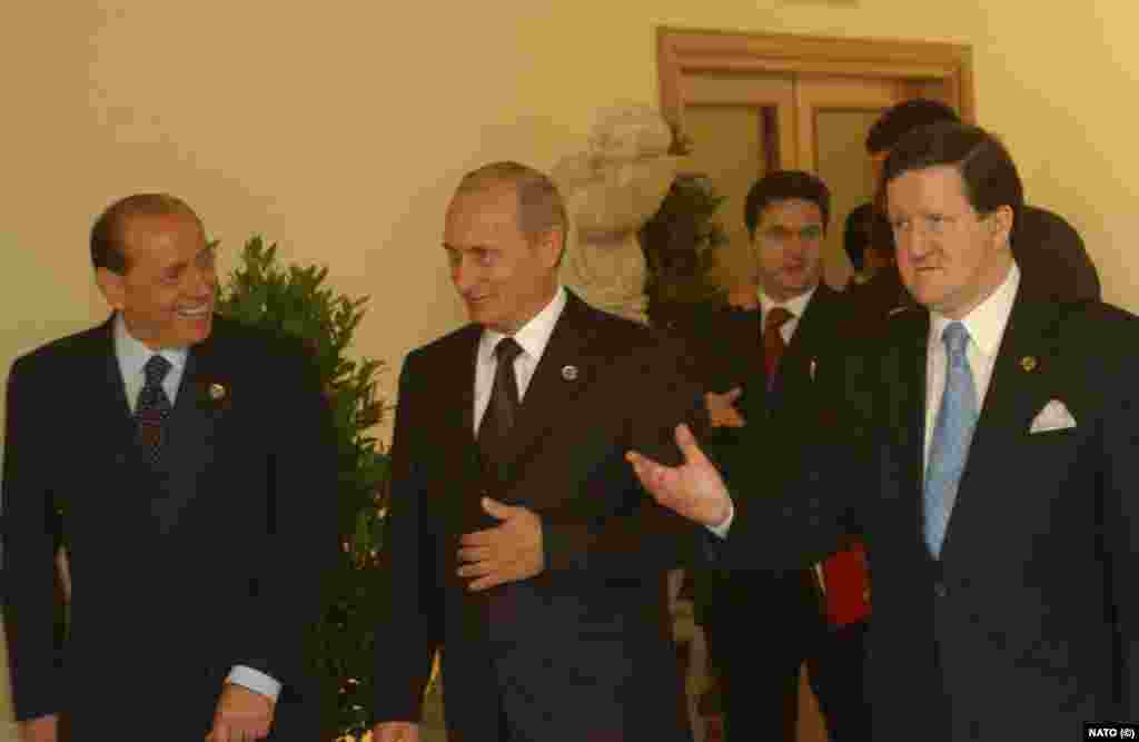 Prim-ministrul Italiei, Silvio Berlusconi (stânga), președintele Vladimir Putin, și secretarul general NATO, Lord Robertson, la summitul din 2002 de la Roma. &bdquo;Roma 2002&rdquo; înseamnă crearea Consiliului NATO - Rusia, ca parteneri egali. &nbsp;21 de ani mai târziu, acest statut era transferat către Ucraina.