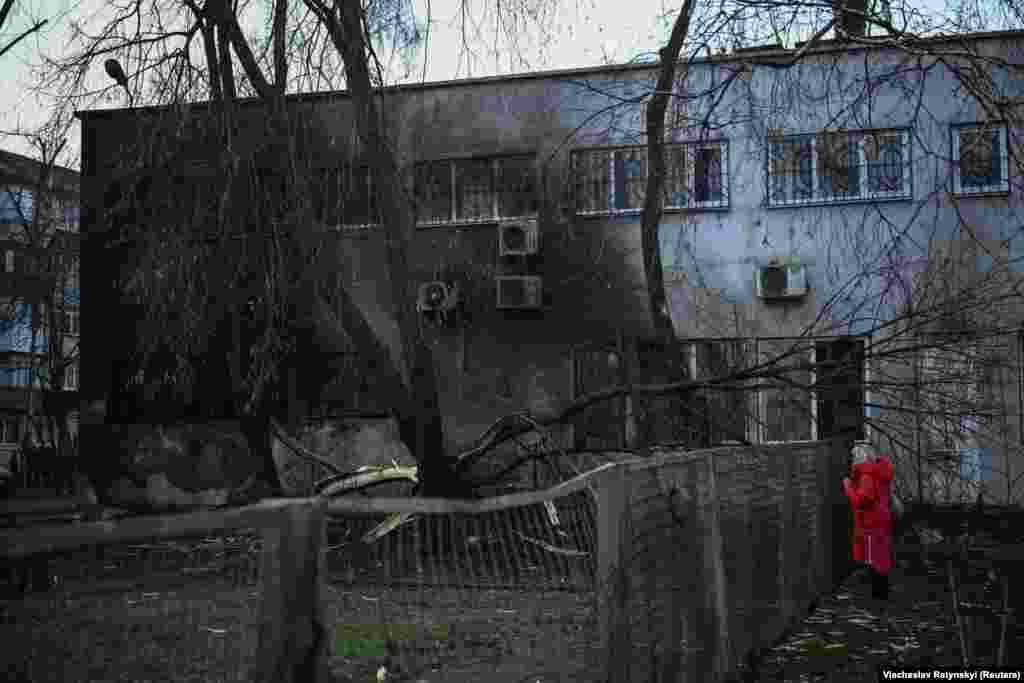 Мешканка дивиться на пошкодження будинку після російської атаки, Київ, 21 березня 2024 року