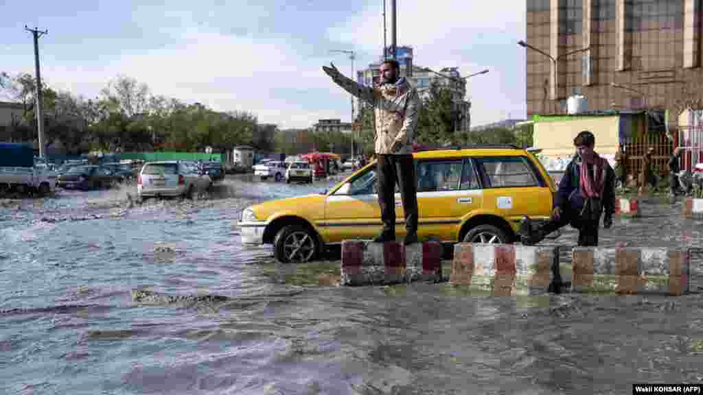 Un polițist de trafic afgan, la datorie, pe un drum inundat din Kabul.