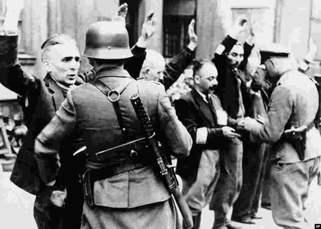 Нацистки военни арестуват граждани във Варшавското гето през пролетта на 1943 г.&nbsp;Немските войници са заловили около 1500 слабовъоръжени бойци, които близо месец са се съпротивлявали срещу танкове и артилерийски части.