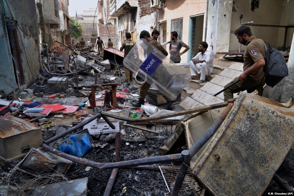 Oficerët e policisë kalojnë nëpër rrënojat e shtëpive të vandalizuara nga një turmë myslimane e zemëruar në një zonë të krishterë në Jaranvala në distriktin Faisalabad, në Pakistan, të enjten e 17 gushtit 2023. Policia arrestoi më shumë se 100 myslimanë gjatë bastisjeve që kreu natën në një zonë në Pakistanin lindor ku një turmë myslimane e zemëruar për përdhosjen e supozuar të Kuranit nga një i krishterë, sulmoi kishat dhe shtëpitë e të krishterëve të pakicave.&nbsp;