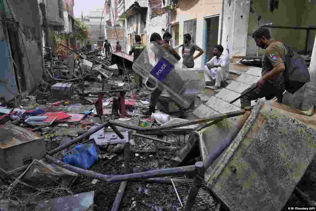 Поліцейські проходять біля&nbsp; будинків, поруйнованих розлюченим мусульманським натовпом у християнському районі Джаранвала в окрузі Фейсалабад, Пакистан, 17 серпня 2023 року. Поліція заарештувала понад 100 мусульман під час нічних рейдів у районі на сході Пакистану, де мусульманський натовп, розлючений нібито оскверненням Корану християнином, напав на церкви і будинки християнських меншин, що змусило владу викликати війська для відновлення порядку, як повідомили офіційні особи. (AP Photo/K.M. Chaudary)