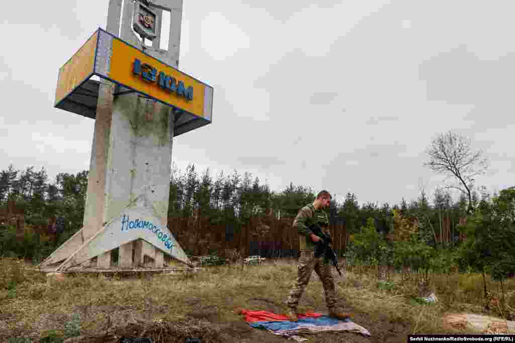 Український військовий фотографується біля стели із синьо-жовтими кольорами міста &laquo;Ізюм&raquo;, звільненого напередодні. Вересень, 2022 року&nbsp;