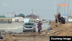 Люди издалека наблюдают за своими домами, стоящими в воде. Кульсары, 9 апреля 2024 года