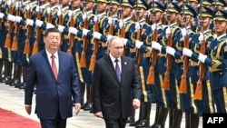 Vladimir Putin (dreapta) a fost primit la Beijing cu o ceremonie descrisă de presa internațională drept grandioasă. Muzica a avut acorduri sovietice.
