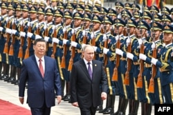 Владимир Путин и Си Цзиньпин проходят мимо почетного караула в аэропорту Пекина во время церемонии встречи. 15 мая 2024 года