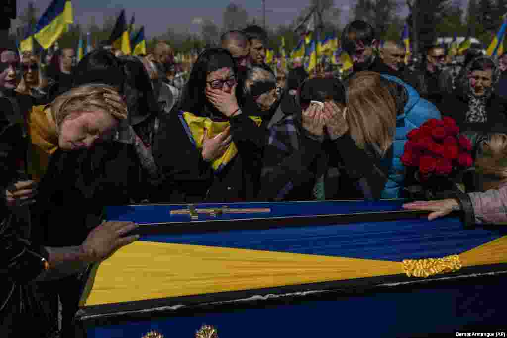 Relatives mourn next to the coffin of Ukrainian soldier Andriy Vorobiov at the Kryviy Rih cemetery in eastern Ukraine.