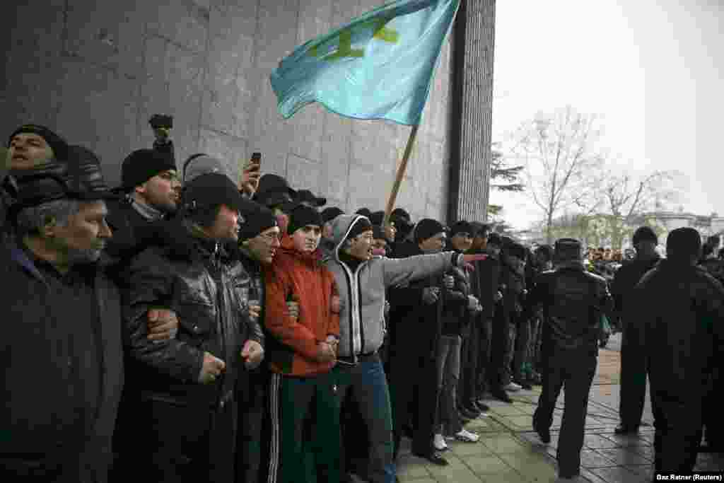 Crimean Tatars hold the flag of their people during a rally at the Crimean parliament in Simferopol on February 26, 2014. One week earlier, a Crimean politician raised the possibility of the peninsula&rsquo;s &ldquo;secession&rdquo; from Ukraine. Kyiv street protesters at the time were in the process of ousting pro-Russian President Victor Yanukovych from power in what Ukrainians came to call the &ldquo;revolution of dignity.&rdquo; &nbsp;