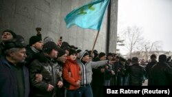 Крымские татары держат флаг своего народа во время митинга у парламента Крыма в Симферополе, 26 февраля 2014 года.<br />
<br />
Неделей ранее крымский политик поднял вопрос о возможности &laquo;отсоединения&raquo; полуострова от Украины. Протестующие на Майдане в Киеве в то время находились в процессе отстранения от власти пророссийского президента Виктора Януковича, позже эти протесты стали называть &laquo;революцией достоинства&raquo;.<br />
&nbsp;