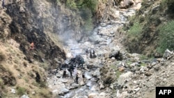 نیروهای پولیس و تیم تحقیقاتی درحال بررسی محل سقوط موتر انجنیران چینی اند که به داخل یک دره سقوط کرده است