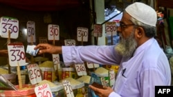 A customer buys rice at a wholesale shop in Karachi.