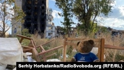 Іграшкове ведмежа на стільці на фоні зруйнованої 9-поверхівки у Вугледарі, жовтень 2023 року